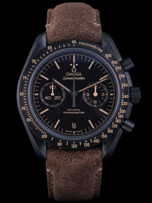An Omega Speedmaster chronograph watch with a black dial, yellow-accented markers, tachymeter bezel, and a rugged brown leather strap