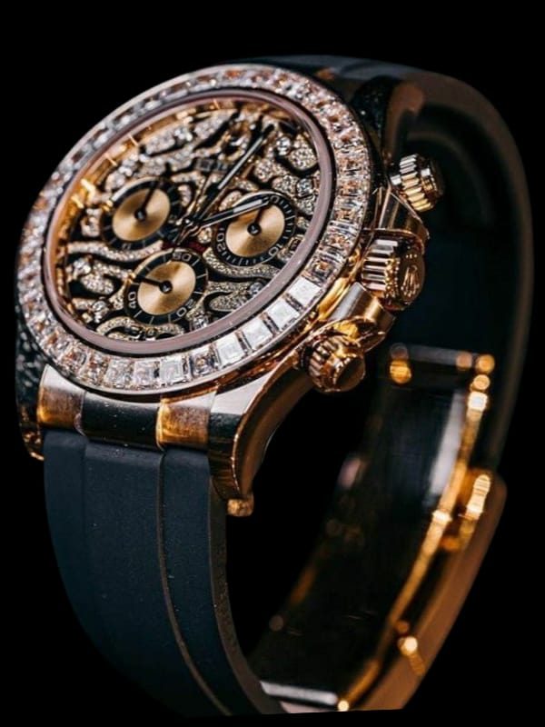 A luxurious Rolex watch with a gold and silver skeleton-style dial, diamond-studded bezel, and a black rubber strap